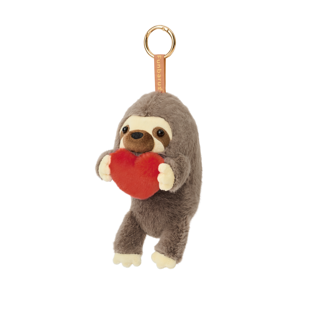 Product image shows Posture Pal Bag Charm, Sloth variant with a brown tag and gold circle clip. Sloth is light brown, dark brown and tan holding a red plush heart between its hands.
