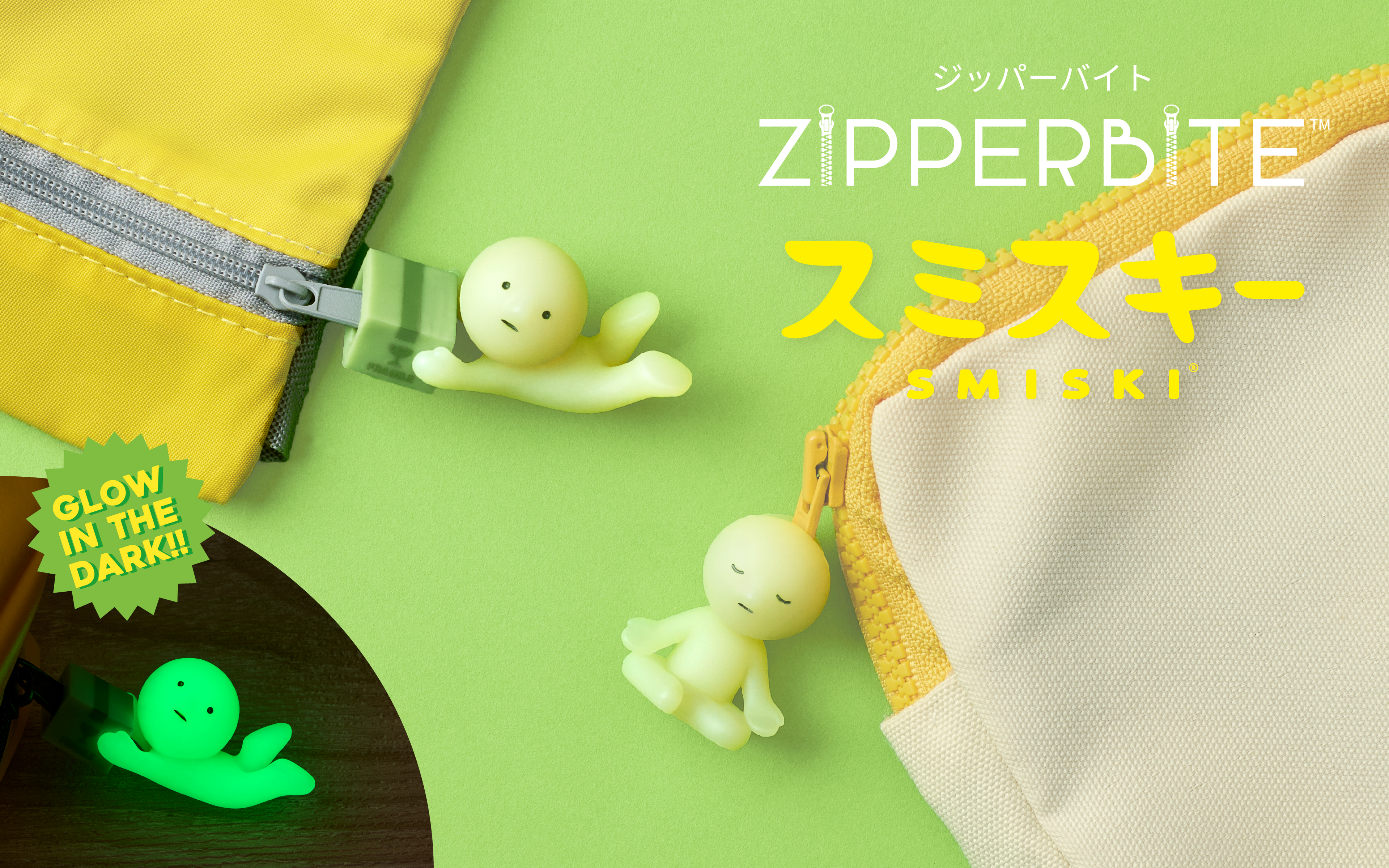 Thumbnail set on a bright green background with white and yellow logo text "ZIPPERBITE" and "SMISKI" written in both English and Japanese. Bottom left corner shows SMISKI Zipperbite in its glow in the dark state with text above that reads "Glow in the dark!". Figures on the image show two zipper pouches with SMISKI Zipperbite attached (left) "Falling Down" and (right) "Lotus Pose"